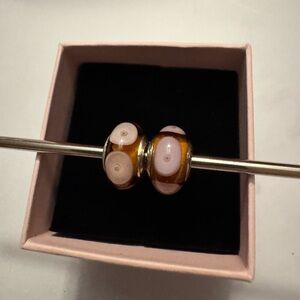 OHM brand glass beads in amber and light pink